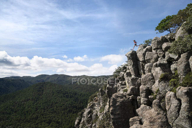 Uno che salta da una roccia all'altra su una cresta molto esposta — Foto stock