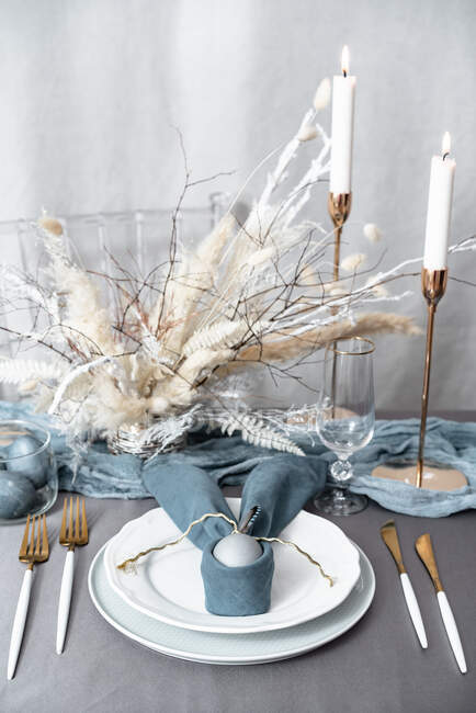 Decken des Ostertisches mit Kerzen und bunten Eiern — Stockfoto