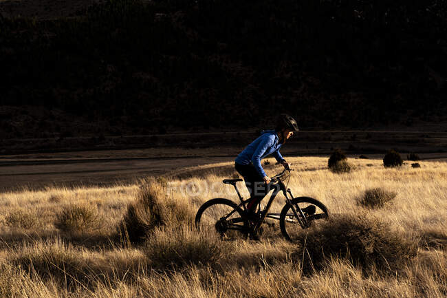 Donna silhouetted mountain bike durante il tramonto — Foto stock