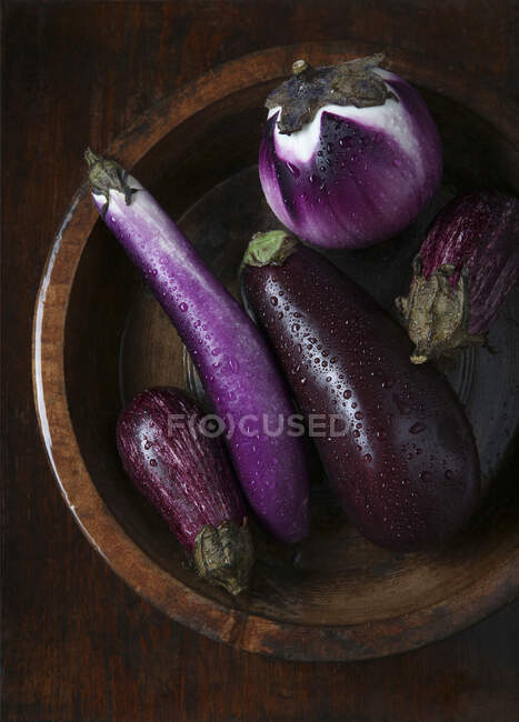 Violet eggplants on wooden background — Stock Photo