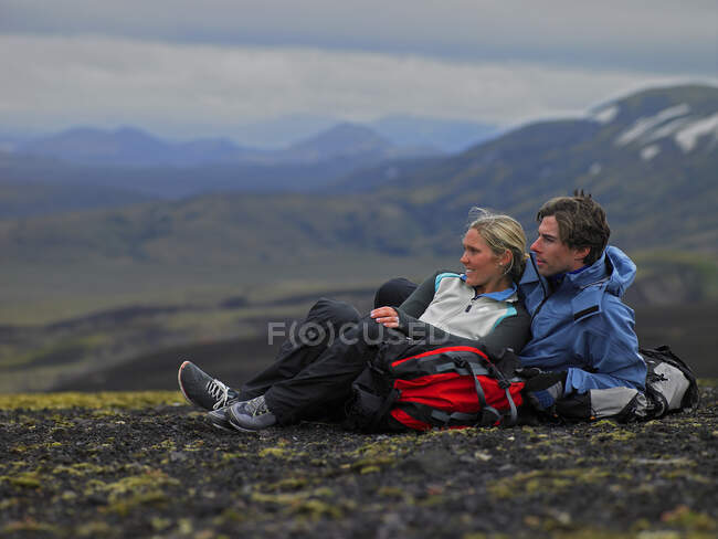 Couple randonnée relaxant à flanc de montagne en Islande — Photo de stock