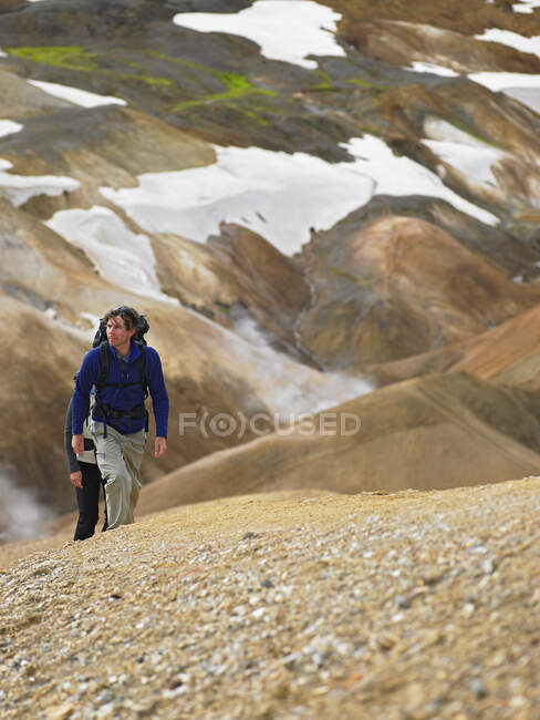 Casal caminhadas até encosta íngreme nas terras altas islandesas — Fotografia de Stock
