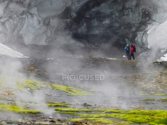 Pareja explorando el glaciar en Hrafntinnusker en Islandia - foto de stock