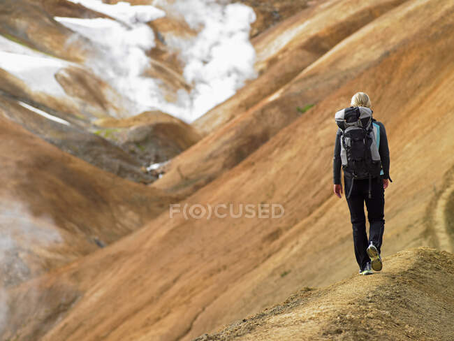 Jovem caminhando ao longo do cume nas terras altas da Islândia — Fotografia de Stock