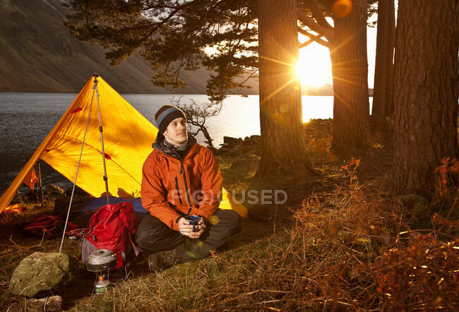 Mann genießt Heißgetränk in einfachem Camp im British Lake District — Stockfoto