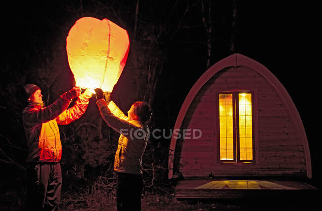 Пара отправляет китайский фонарь в кемпинг — стоковое фото