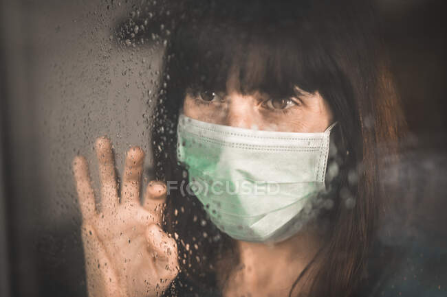 Ein junges Mädchen trägt bei der Covid-19-Pandemie eine Maske mit aufgesetzter Hand — Stockfoto
