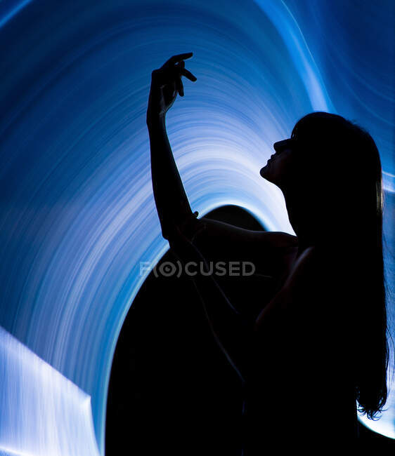 Silueta de la mujer a través de la luz lightpainting - foto de stock