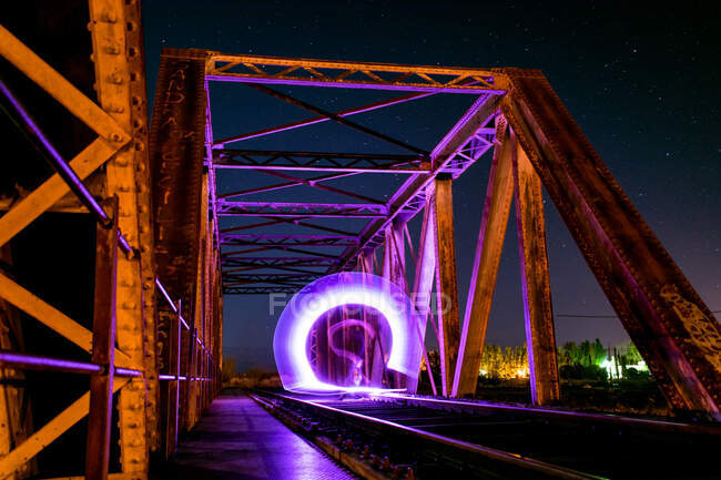 Lightpainting on train bridge at night — Stock Photo