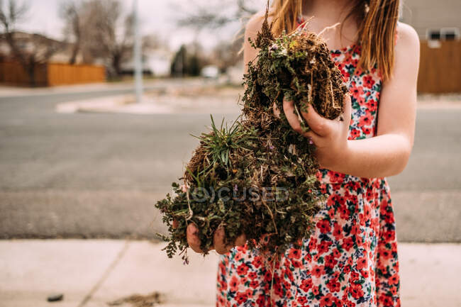 Zugeschnittenes Bild eines jungen Mädchens hält große Stücke Schmutz — Stockfoto