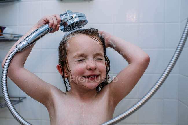 Muchacha joven lavándose el pelo en el baño - foto de stock