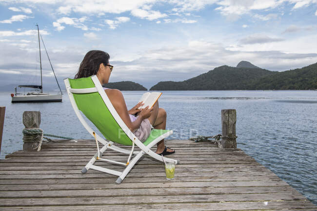 Femme se relaxant sur la jetée sur l'île tropicale d'Ilha Grande — Photo de stock