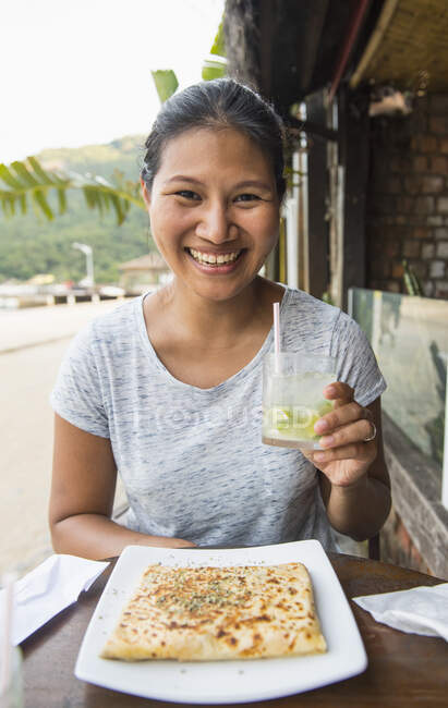 Mulher desfrutando de uma bebida e um lanche na Ilha Grande tropical — Fotografia de Stock