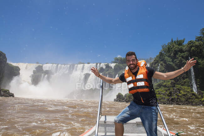 Joven posando frente a las cascadas de Iguacu en Argentina - foto de stock