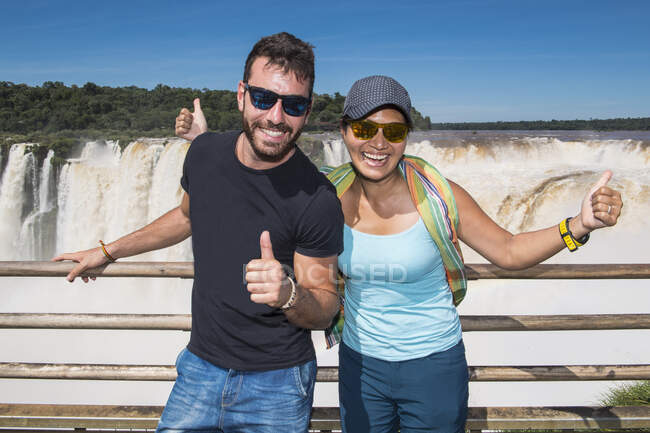 Paar posiert am Wasserfall Teufelskehle bei den Iguazu-Wasserfällen — Stockfoto