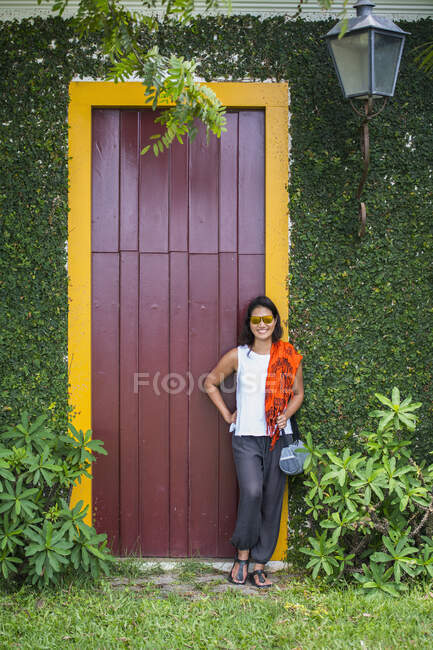Frau posiert vor Tür mit gelbem Rahmen in Paraty / Brasilien — Stockfoto