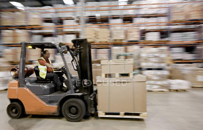 Forklift truck speeding through warehouse — Stock Photo