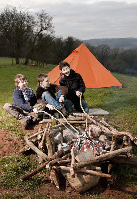 Three boys sitting at campfire in South Wales — Stock Photo