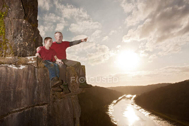 Father and son sitting on a ledge — Stock Photo