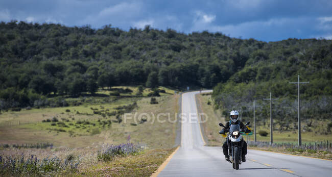 Жінку водіння її мотоцикл самотньо дороги в Патагонії, Чилі — стокове фото