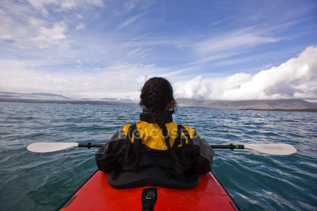 Asian woman in kayak on glacier lagoon — Stock Photo