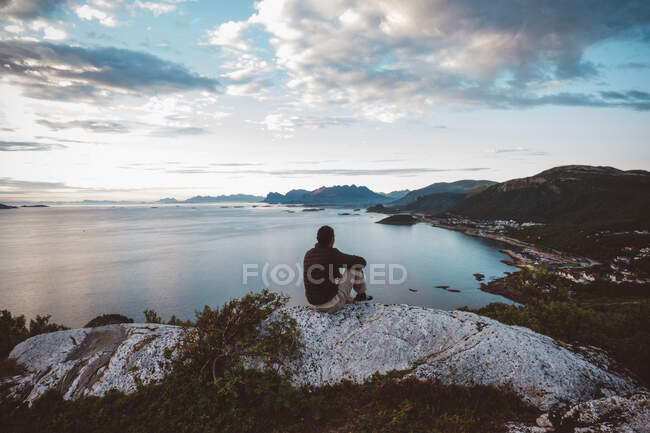 Wanderer sitzt auf einem Felsen und blickt auf Meer und Inseln — Stockfoto