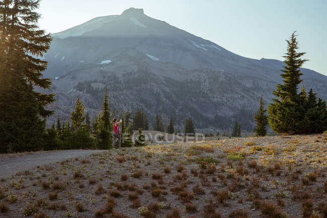 Young woman far away on trail near mountain — Stock Photo