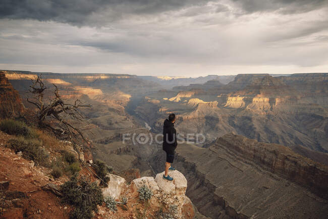 El hombre observa el atardecer sobre el gran cañón - foto de stock