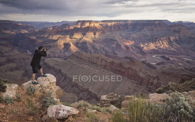 Чоловік фотографує великий каньйон на сході сонця — стокове фото