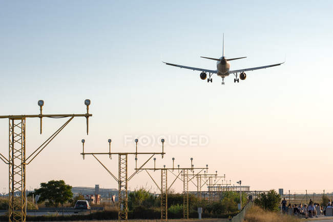 Airplane landing at sunset — Stock Photo