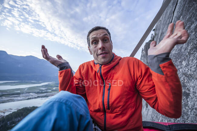 Man with surprised look showing interrogation on portaledge at sunset — Stock Photo