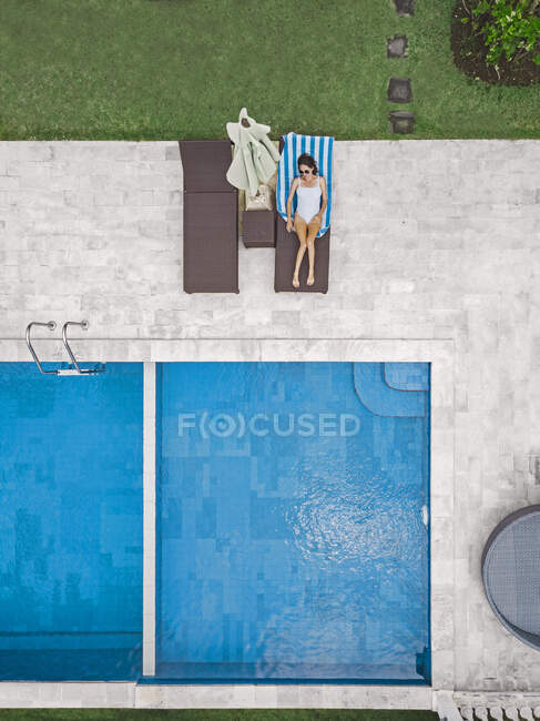 Top aerial view of woman relaxing around swimming pool during weekend — Stock Photo