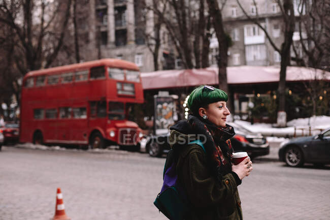 Portrait of non-binary female hipster standing on street in city during winter — Stock Photo