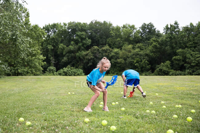 Menina com cabelo louro encaracolado joga jogos de gramado no dia de campo na escola — Fotografia de Stock