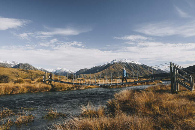 A young woman hikes towards the summit of Mt Sunday, Southern Alps, Canterbury, New Zealand. — Stock Photo