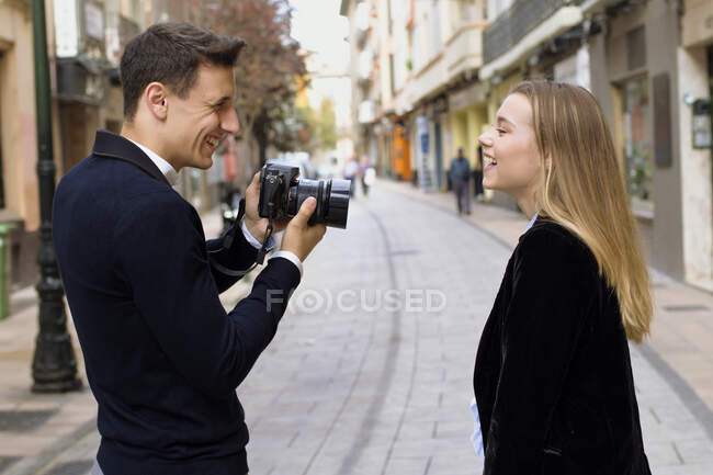 Un jeune homme photographie son ami dans la rue d'une ville européenne — Photo de stock