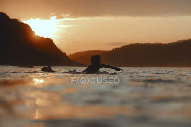 Surfista no mar ao pôr do sol, Lombok, Indonésia — Fotografia de Stock