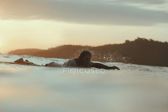 Серфер у морі після заходу сонця, Ломбок, Індонезія. — стокове фото