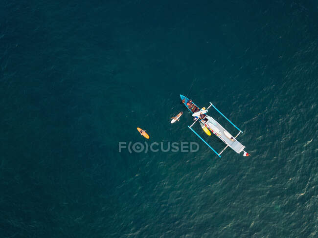 Vue aérienne des surfeurs et du bateau dans l'océan, Lombok, Indonésie — Photo de stock