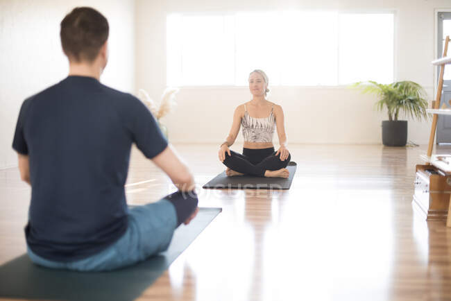 Uma menina e um cara em uma sessão de ioga. — Fotografia de Stock