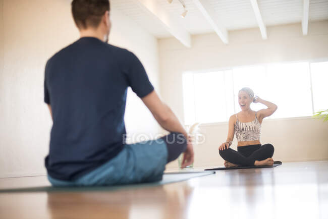 Una chica se ríe durante una sesión de yoga. - foto de stock