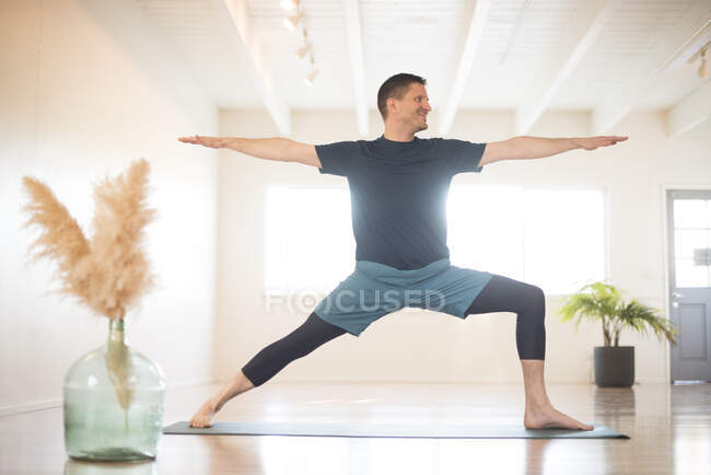 Un ragazzo in Warrior 2 posa durante lo yoga. — Foto stock