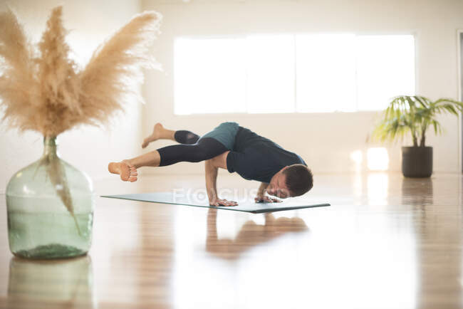 A guy in hurdlers pose during yoga. — Stock Photo