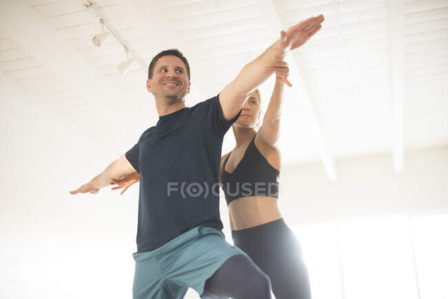Un professeur de yoga ajustant son élève. — Photo de stock
