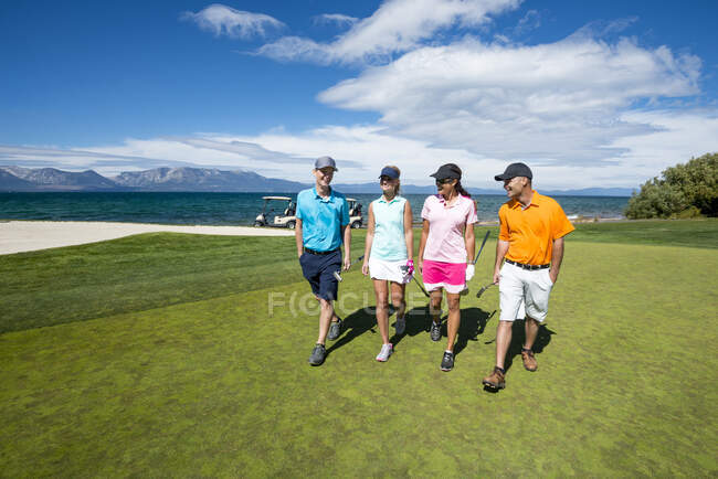 Four people playing golf at Edgewood Tahoe in Stateline, Nevada. — Stock Photo