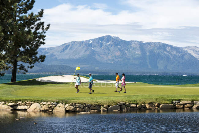 Un grupo de amigos jugando al golf en Edgewood Tahoe en Stateline, Nevada. - foto de stock