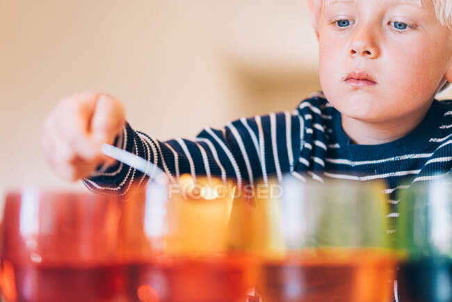 Young boy dying easter eggs — Stock Photo