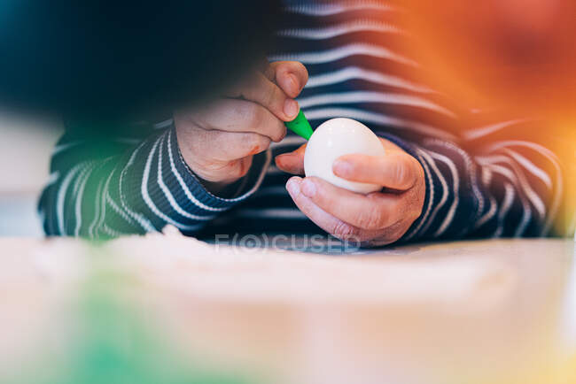 Junge färbt ein Osterei — Stockfoto
