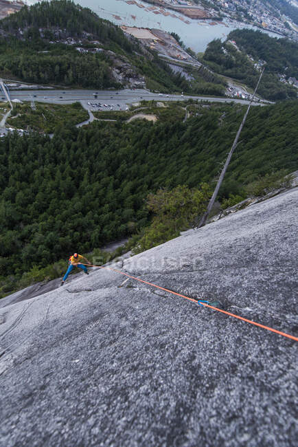 Hombre escalando en roca de montaña - foto de stock