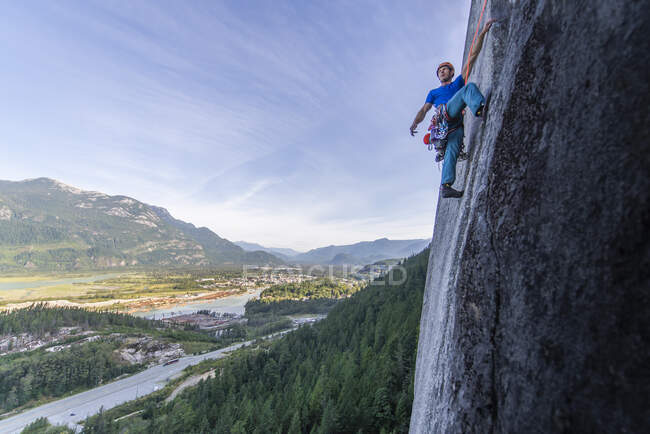 Junger Mann klettert im Wald auf Felsen — Stockfoto